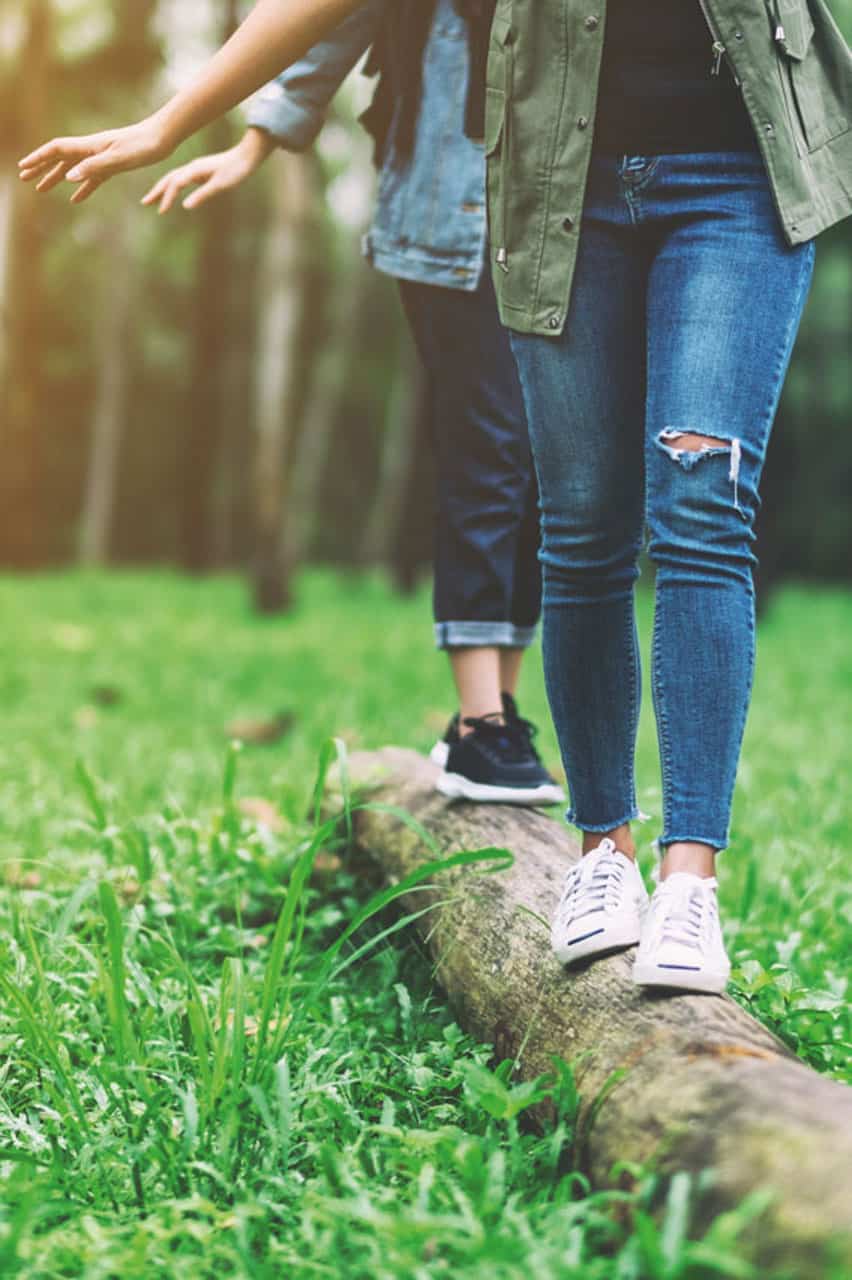 Group-of-traveler-walking-on-the-log-while-hiking-in-the-forest_web